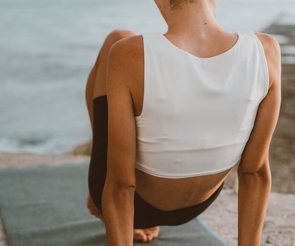 Person feeling energized and stretching outdoors at sunrise.